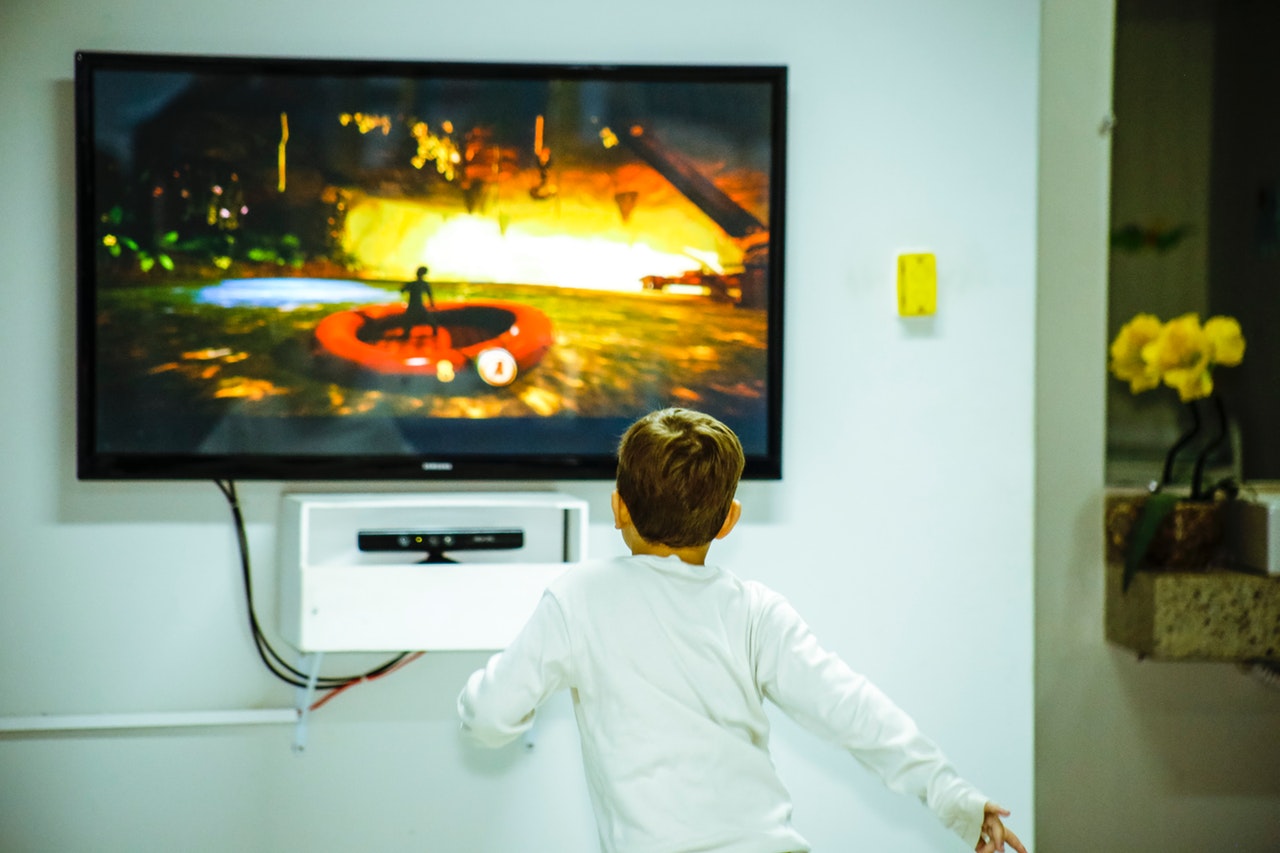 boy-standing-in-front-of-flat-screen-tv