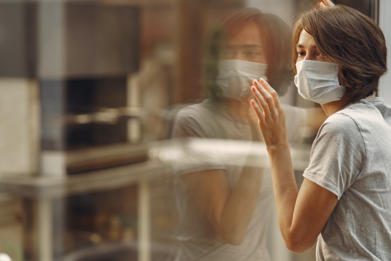 woman-in-gray-t-shirt-covering-face-with-white-mask