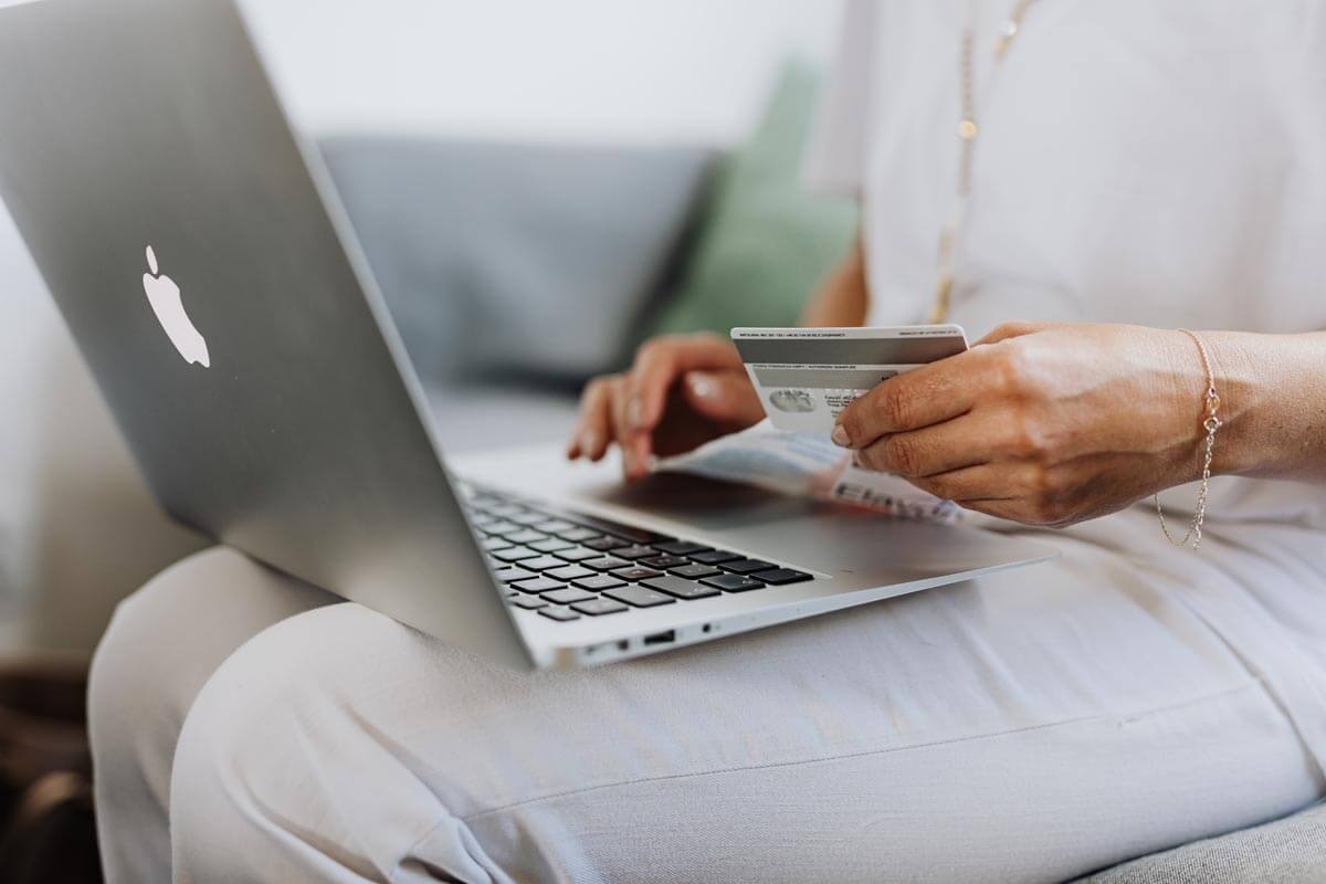 Person-Using-a-Macbook-and-Holding-a-Credit-Card-1